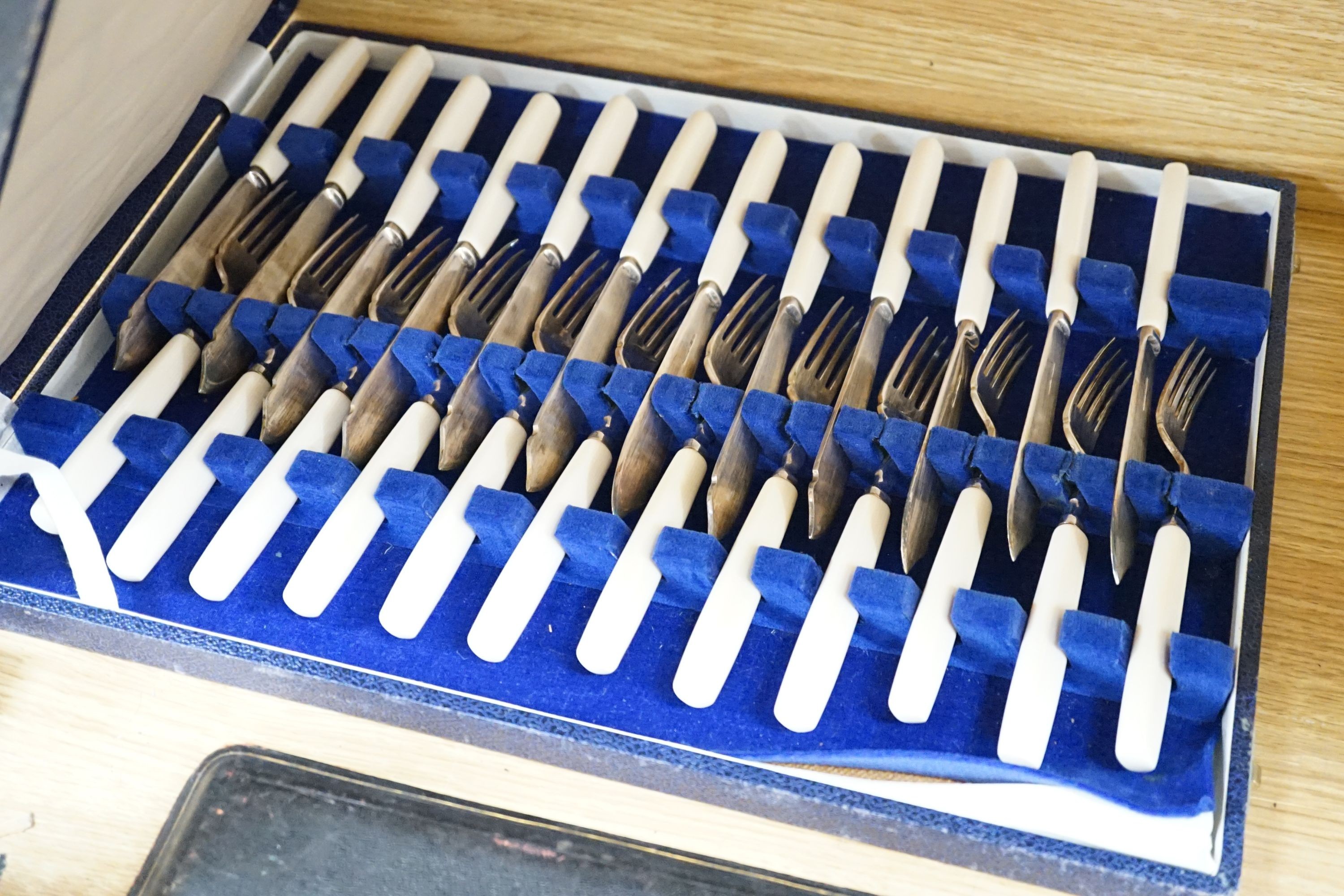 A cased modern silver three piece condiment set, a cased set of twelve Edwardian silver teaspoons, London, 1903 (lacking tongs) and two plated fish services.